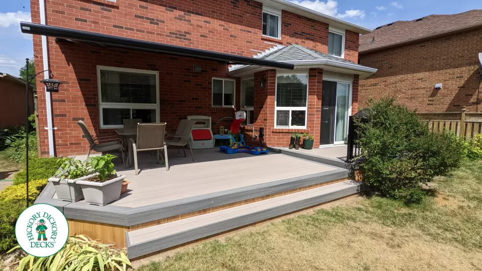 Grey composite deck with dark grey border, cedar skirt, and aluminum picket railing.
