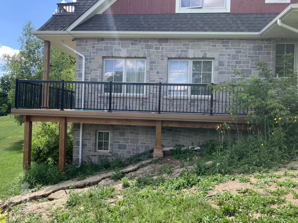 large high cedar deck with cedar pergola and black aluminum railing.