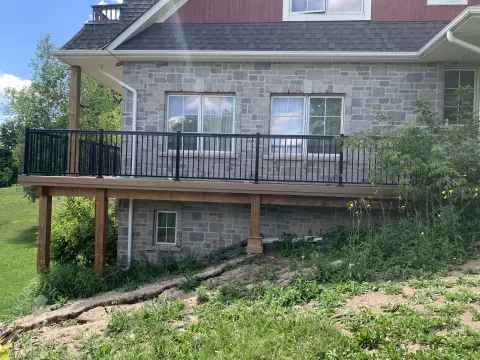 large high cedar deck with cedar pergola and black aluminum railing.