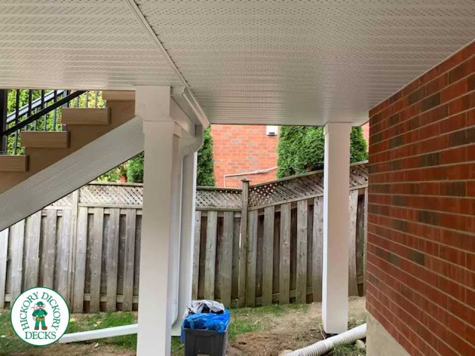 High composite deck with stairs that lead to pool and glass style railings.