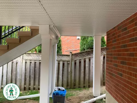 High composite deck with stairs that lead to pool and glass style railings.