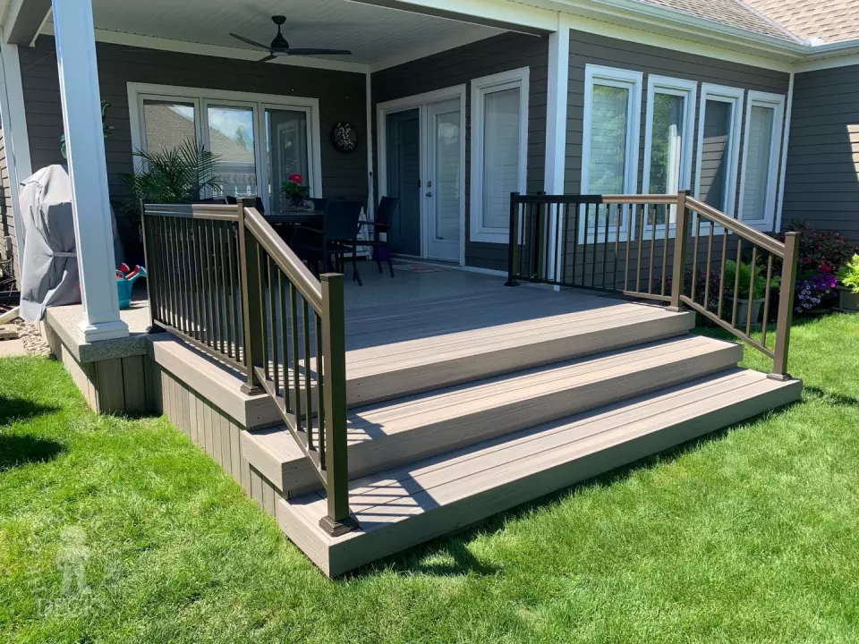 Small covered grey composite porch with aluminum railing.