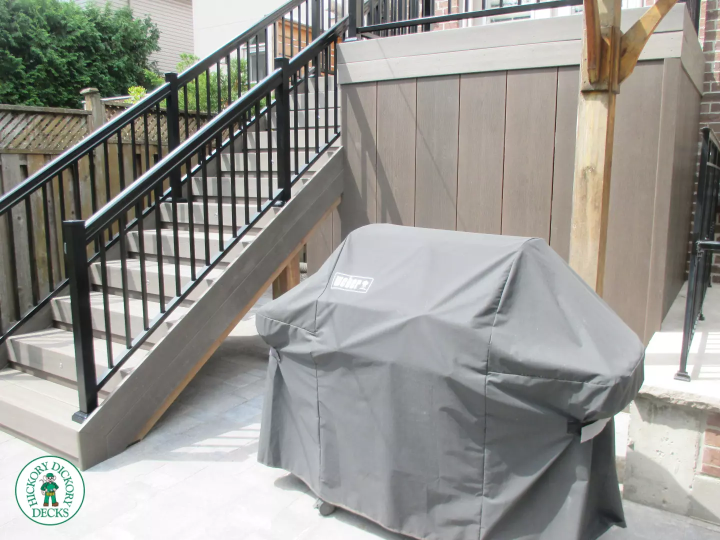 Elevated grey clubhouse deck with black aluminum railing and lights in steps.