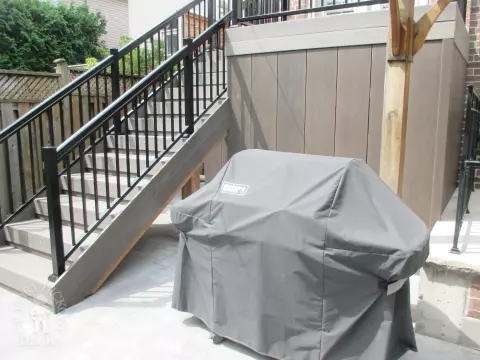 Elevated grey clubhouse deck with black aluminum railing and lights in steps.