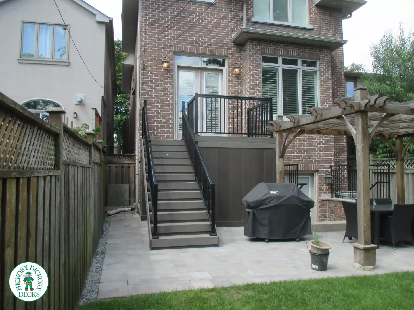 Elevated grey clubhouse deck with black aluminum railing and lights in steps.