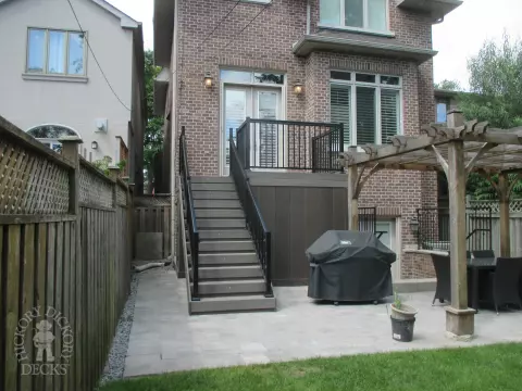 Elevated grey clubhouse deck with black aluminum railing and lights in steps.