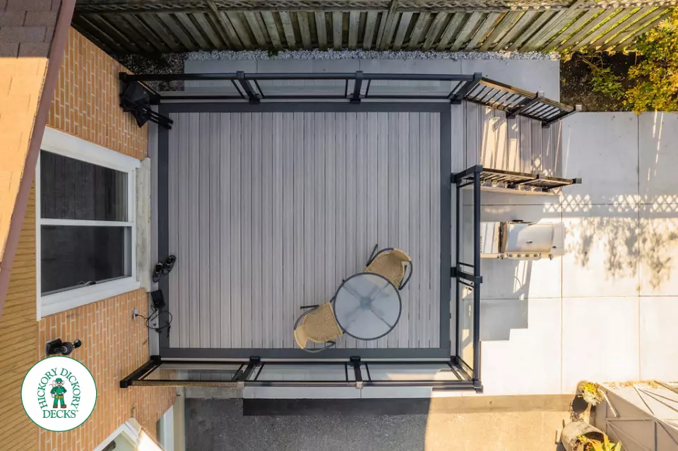 Mid rise grey composite deck with glass railings and a dark grey border.