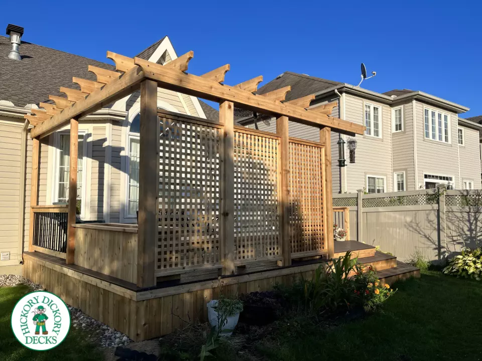Mid size clubhouse deck in brown with cedar skirt, benches, planters, and a pergola.