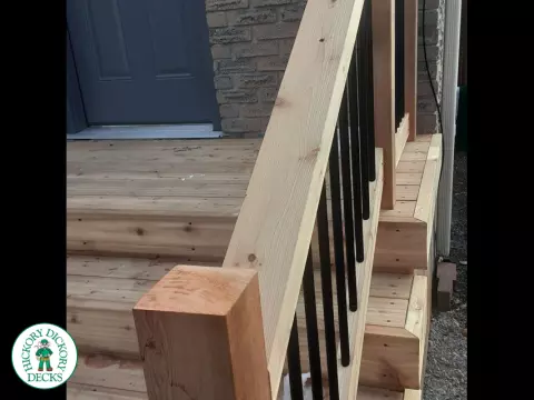 Small cedar porch with stairs and cedar railing.