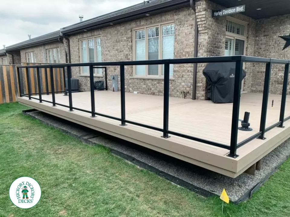 400 square foot beige composite deck with glass railings.