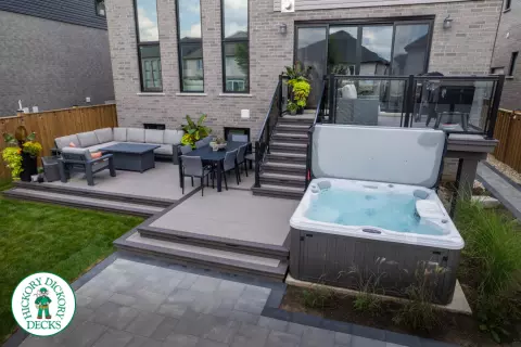 2 level brown composite deck with unique stairs and black aluminum railing. in Waterloo