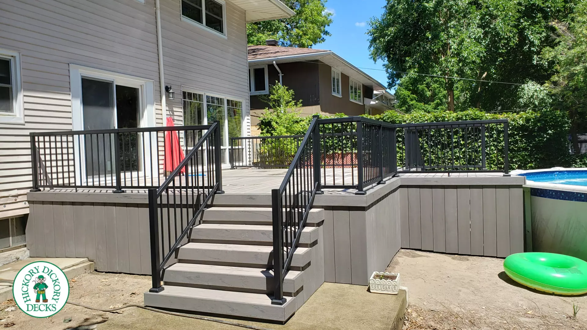 Grey above ground pool deck with black aluminum railings
