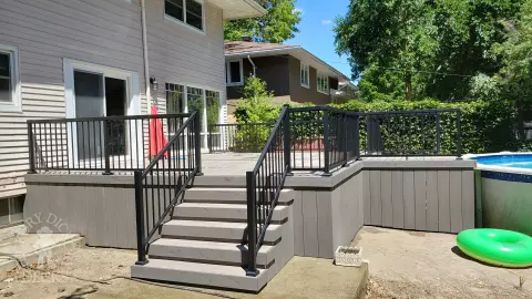 Grey above ground pool deck with black aluminum railings