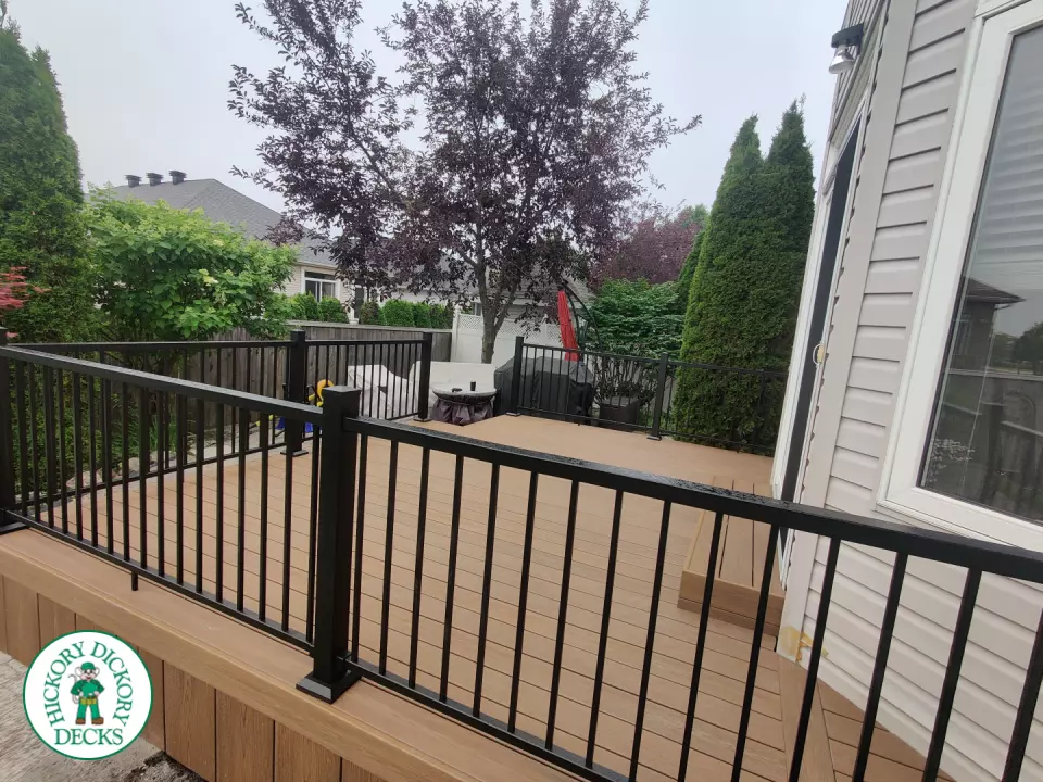 192 square foot fiberon in brown with three steps up to deck and black aluminum railing.
