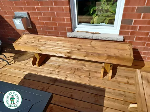 Mid rise pressure treated deck with glass railings, steps, and a custom cedar privacy screen