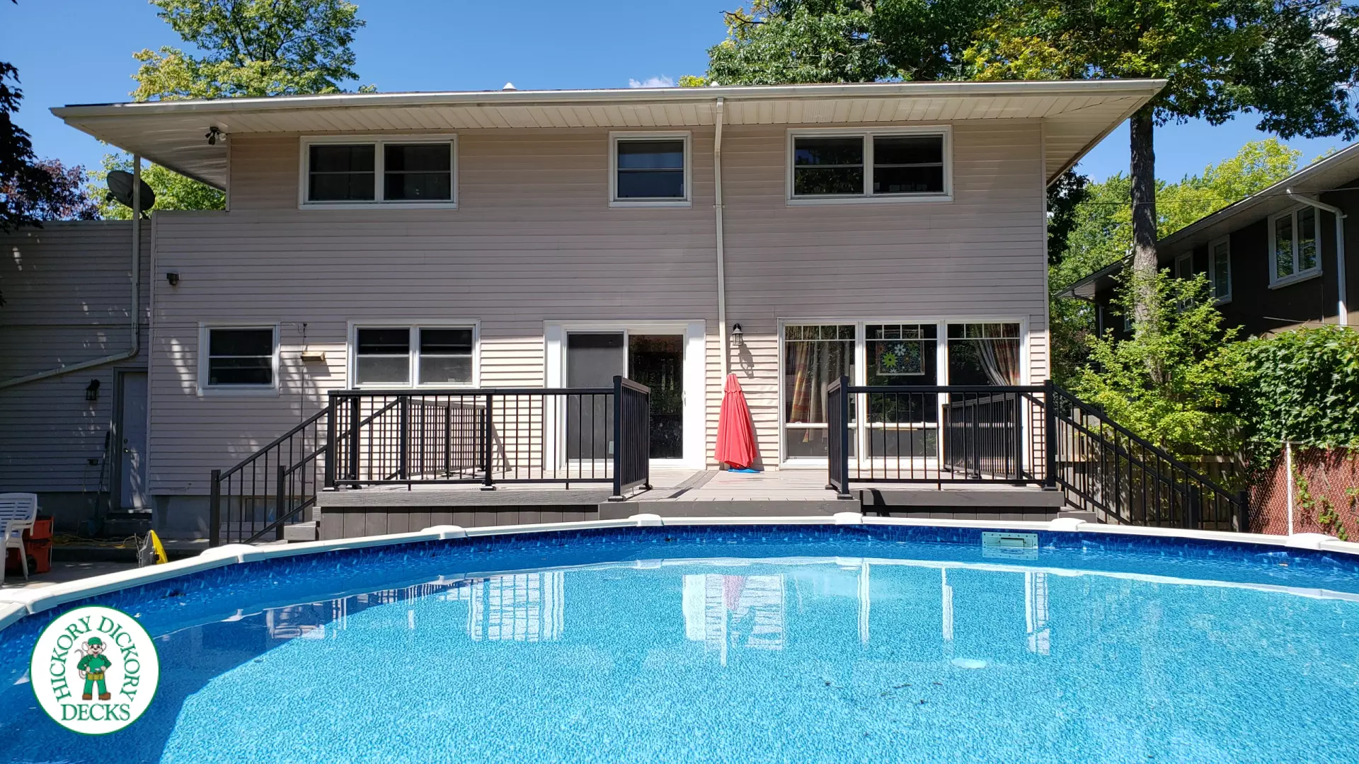 Grey above ground pool deck with black aluminum railings