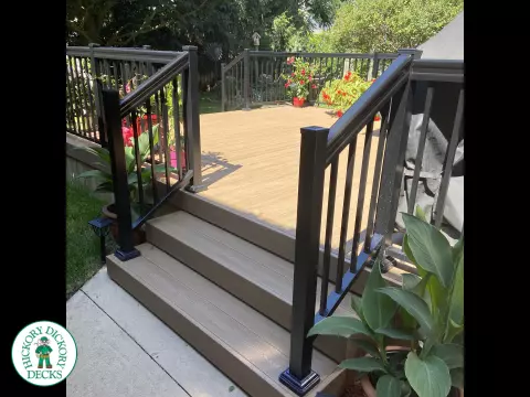 3 steps leading to small brown clubhouse deck with black aluminum railing.