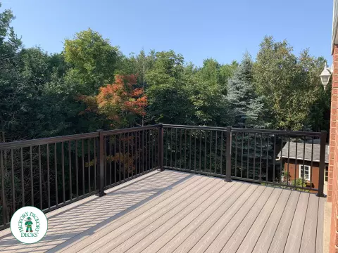 Balcony and deck both in grey Fiberon, with black aluminum railing on balcony.