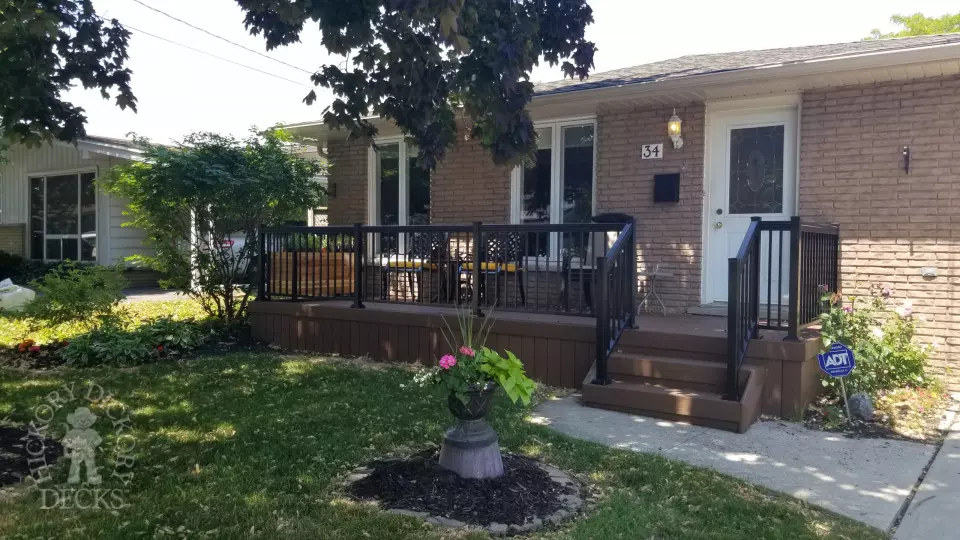 Small brown fiberon porch with black aluminum railing.