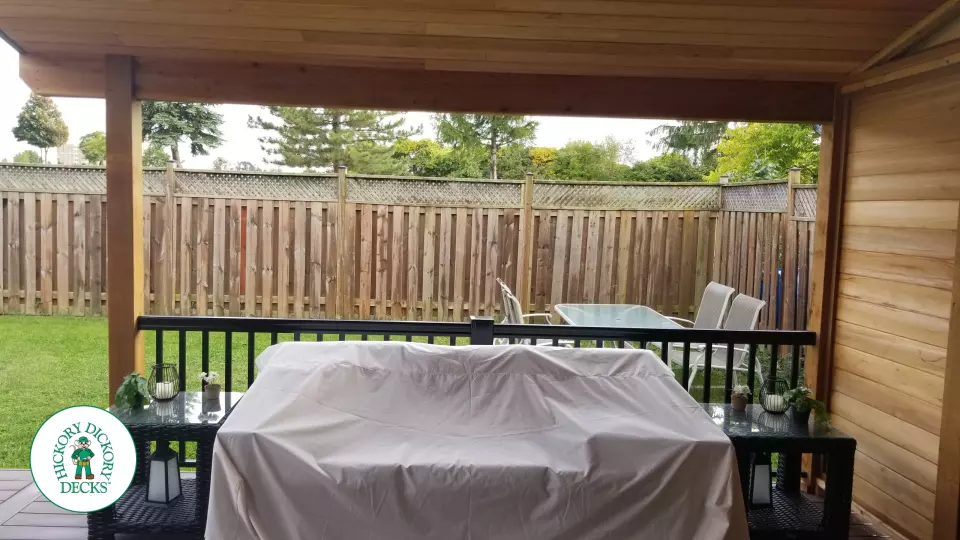 Low brown Veka deck with custom roof structure, black aluminum railing, and lights in steps.