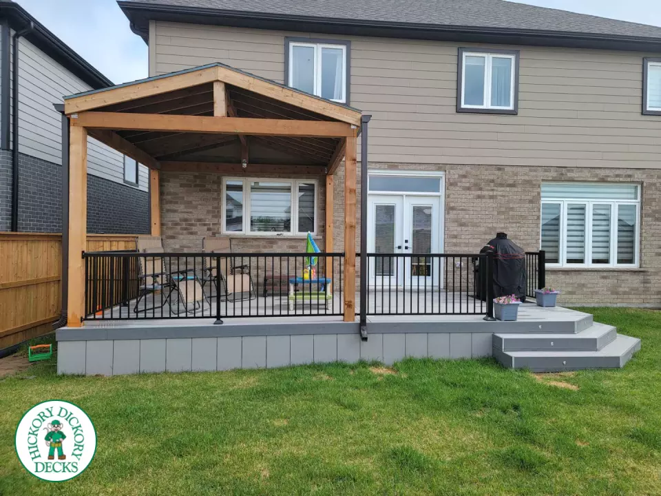 Large grey clubhouse deck with black aluminum railing and a custom cedar roof structure