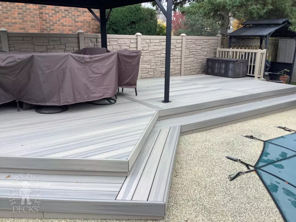 Grey pool deck with curved steps.