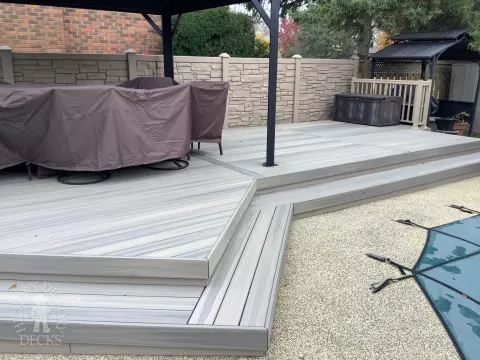 Grey pool deck with curved steps.