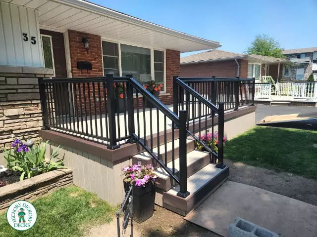 Large front porch in clay with a dark brown border and aluminum railings.