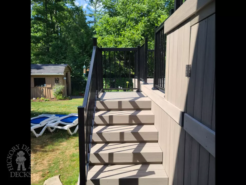 2 level grey composite deck with black aluminum railing.