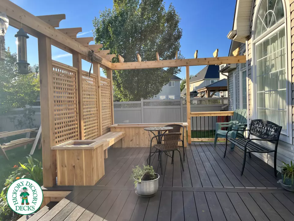Mid size clubhouse deck in brown with cedar skirt, benches, planters, and a pergola.
