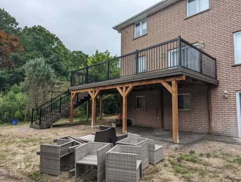 High clubhouse deck with stairs leading up to top, and black aluminum railing.
