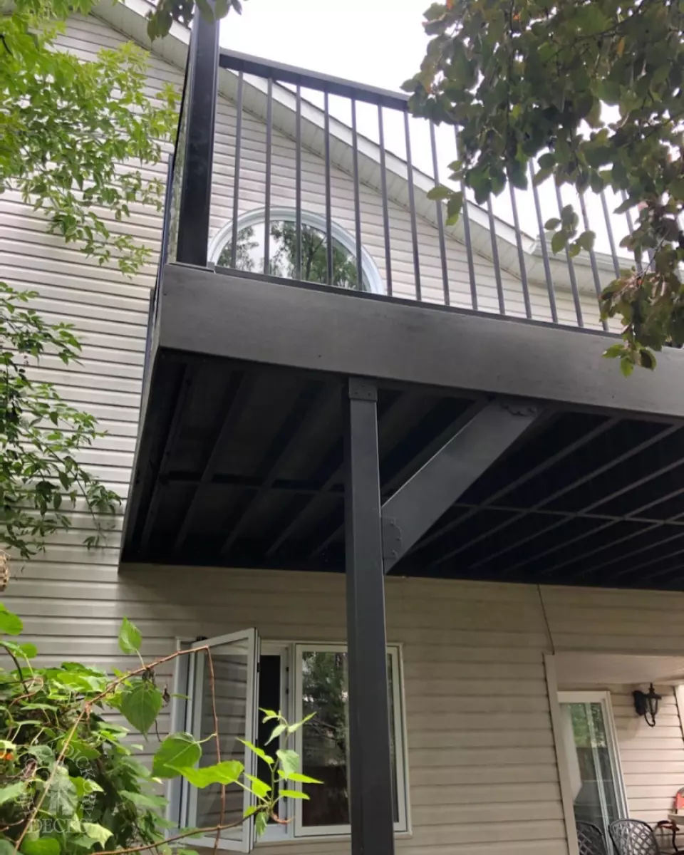 High clubhouse deck in dark grey with black aluminum railing and black privacy screen.