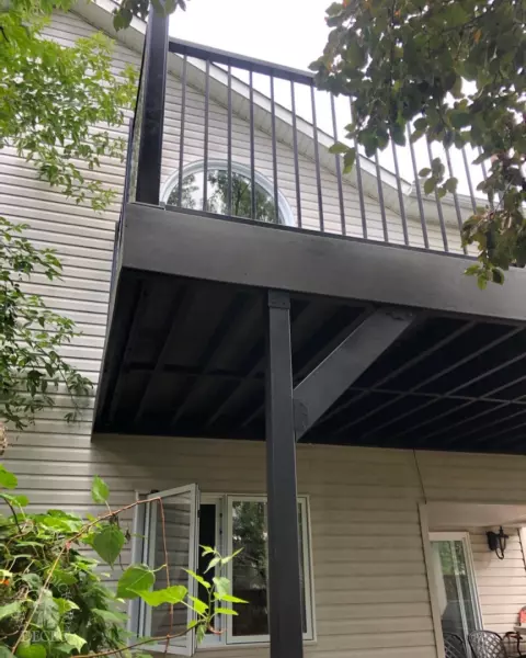 High clubhouse deck in dark grey with black aluminum railing and black privacy screen.