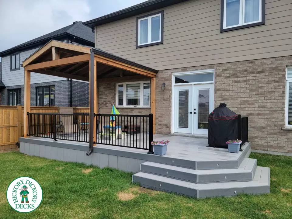 Large grey clubhouse deck with black aluminum railing and a custom cedar roof structure