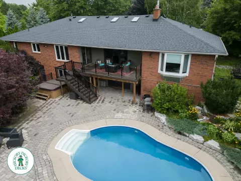 High brown deck with glass railings and lights in the stairs.