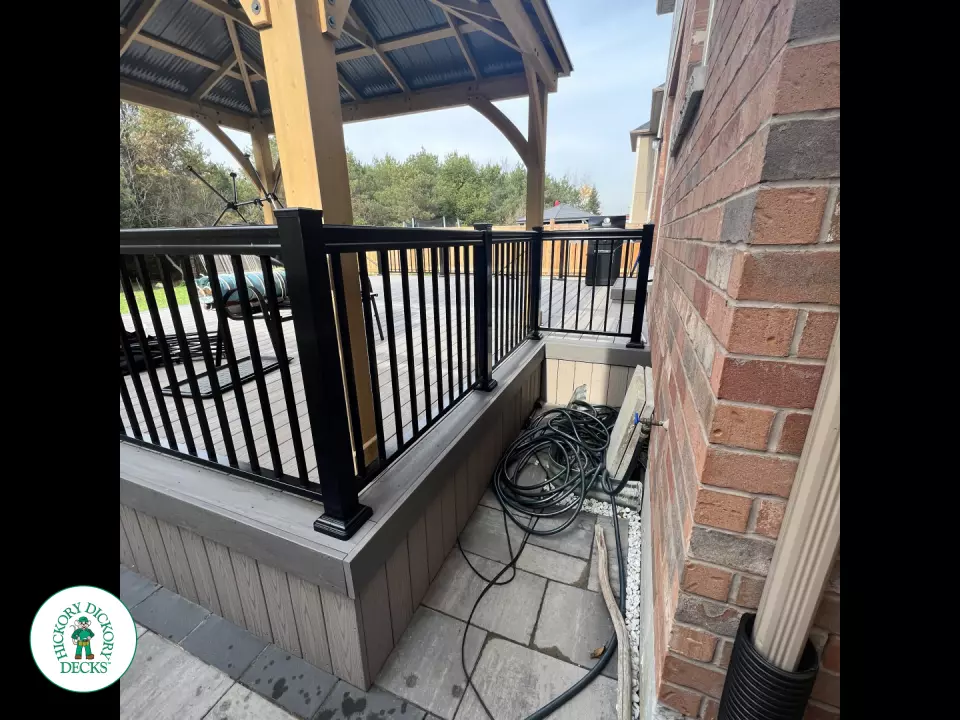 3 steps leading to a large Azek deck with lighting in the steps, and black aluminum railings.