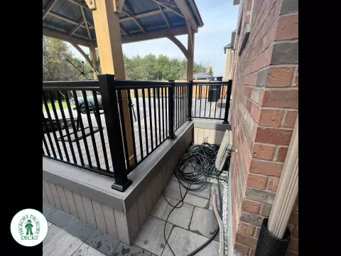 3 steps leading to a large Azek deck with lighting in the steps, and black aluminum railings.