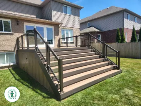 Small landing outside back door with stairs and glass railing.