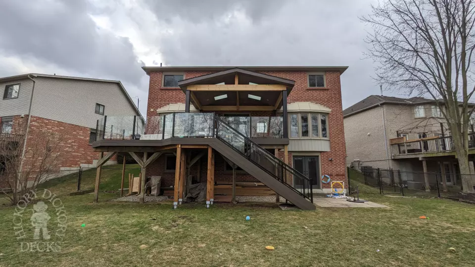 Large high Fiberon deck in brown. Glass railings and skylights in the custom roof structure.