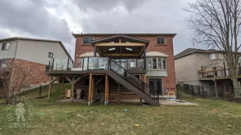 Large high Fiberon deck in brown. Glass railings and skylights in the custom roof structure.