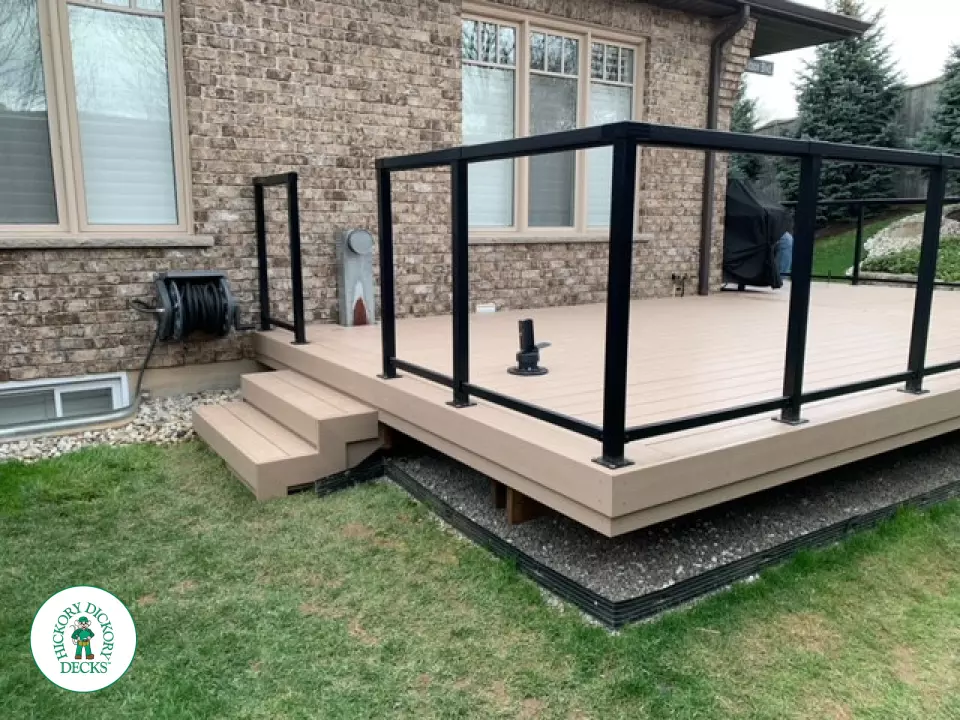 400 square foot beige composite deck with glass railings.