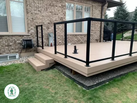 400 square foot beige composite deck with glass railings.