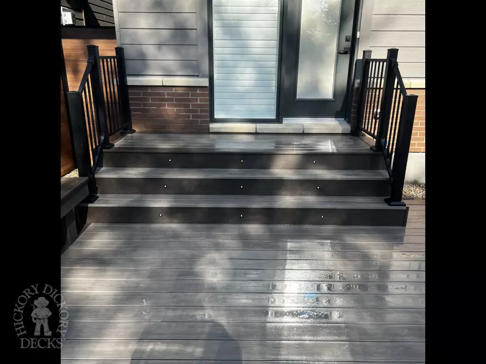 Grey Clubhouse deck with dark grey border, lighting in steps, and a custom bench.