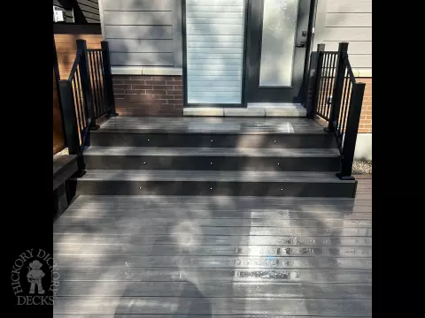 Grey Clubhouse deck with dark grey border, lighting in steps, and a custom bench.