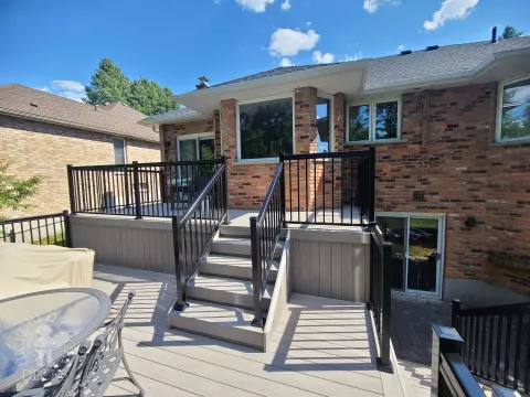 2 level grey composite deck with black aluminum railing.