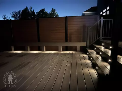 Grey Clubhouse deck with dark grey border, lighting in steps, and a custom bench.