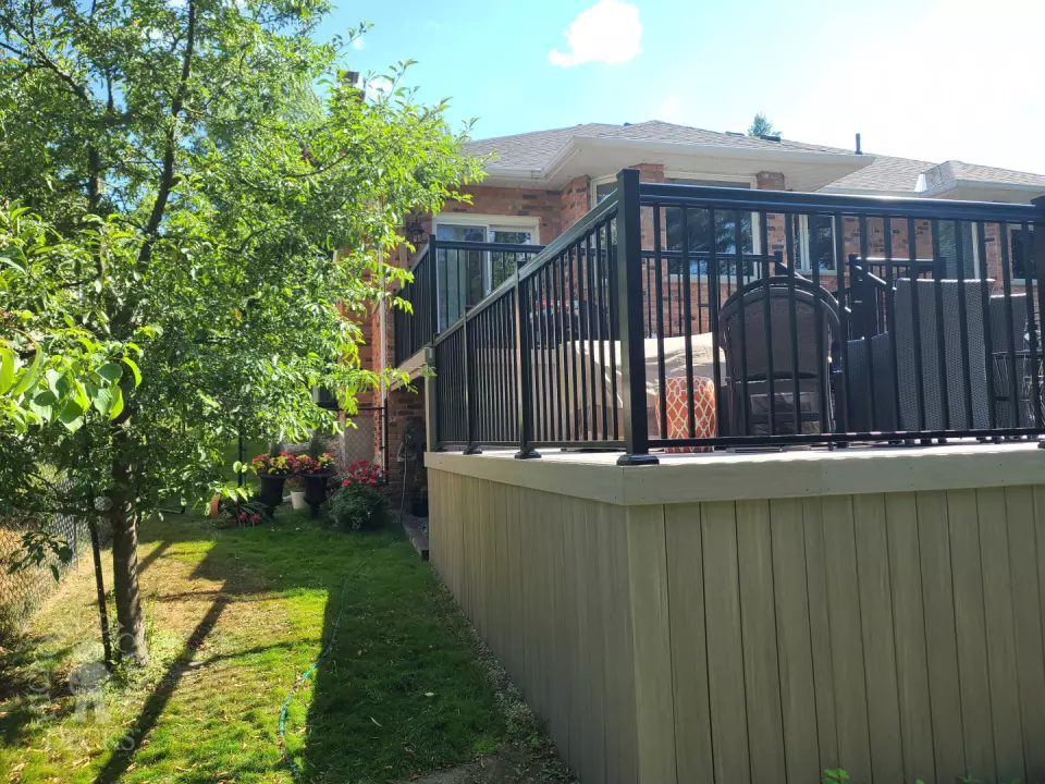 2 level grey composite deck with black aluminum railing.