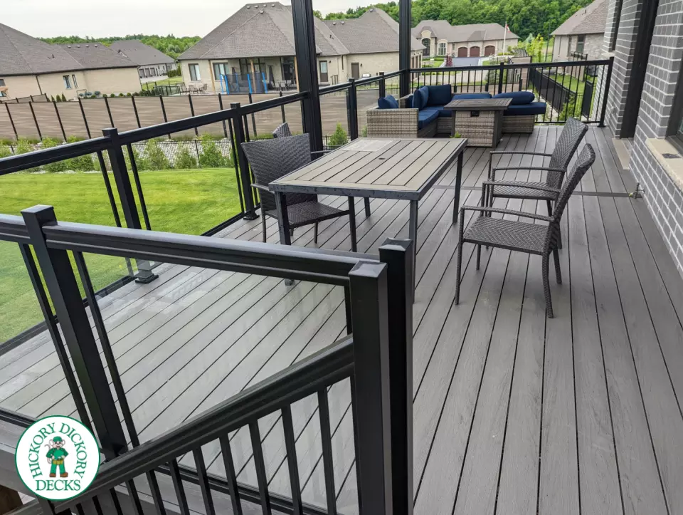 Large high grey trunorth deck with glass railings, and a custom roof structure.