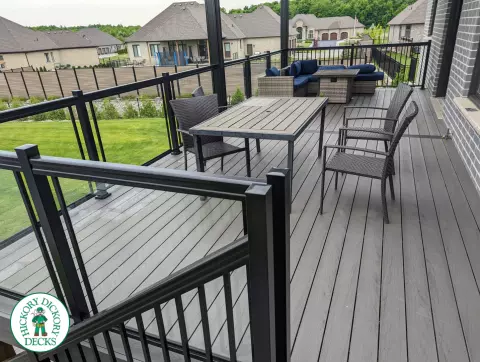Large high grey trunorth deck with glass railings, and a custom roof structure.