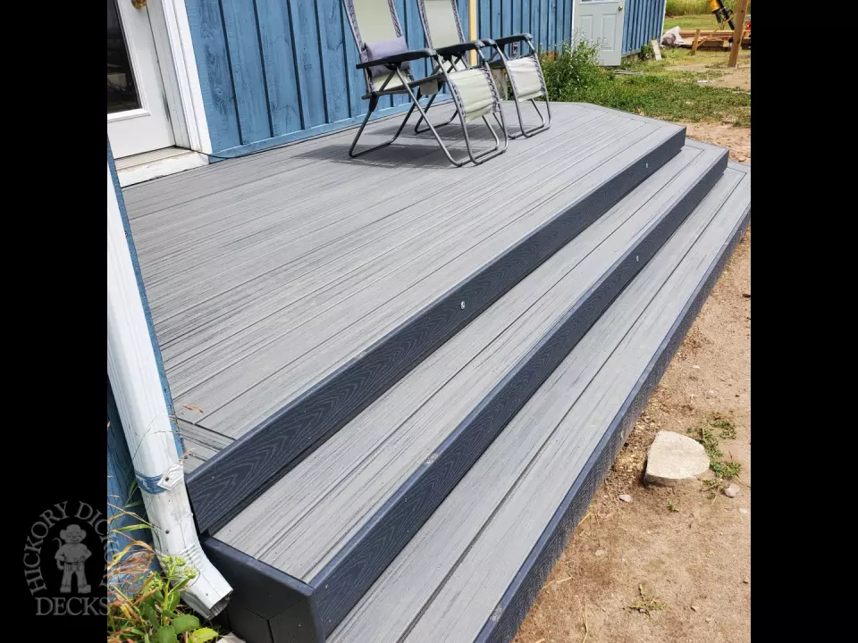 Small grey composite deck with angles steps leading to backyard